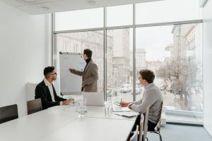 Three professionals engaged in a business meeting in a bright conference room.